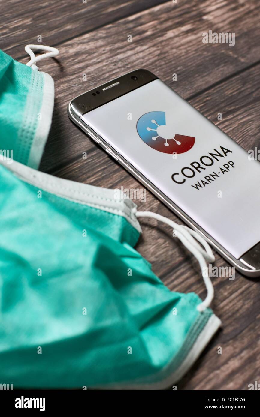 Coronavirus Warn App für COVID-19 Kontaktverfolgung und -Verfolgung mit Gesichtsmasken auf Holzoberfläche Stockfoto