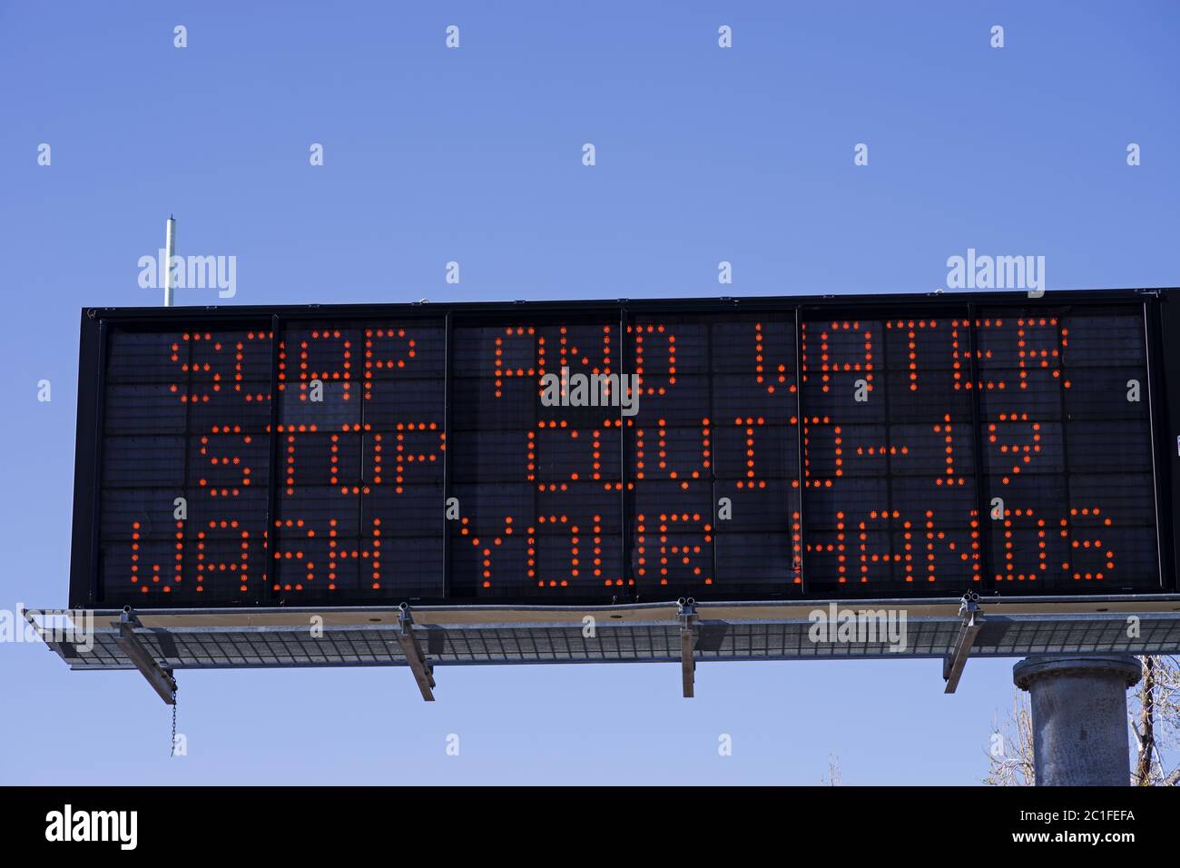 Seife und Wasser stoppen COVID-19 waschen Sie Ihre Hände Autobahn Warnschild Stockfoto