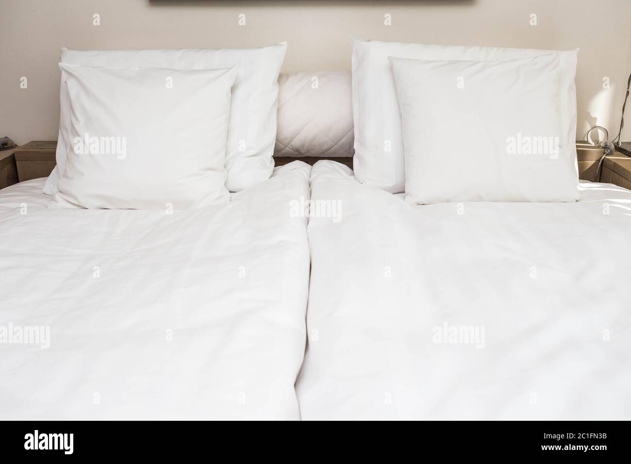 Bett Magd mit sauberen weißen Kissen und Bettwäsche in Schönheit. Close-up. Objektiv Flair im Sonnenlicht. Stockfoto