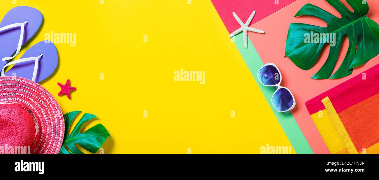 Strandzubehör im Minimal Colorful Design - Flip-Flops und Handtuch mit gestreiftem Hut und tropischen Blättern Stockfoto