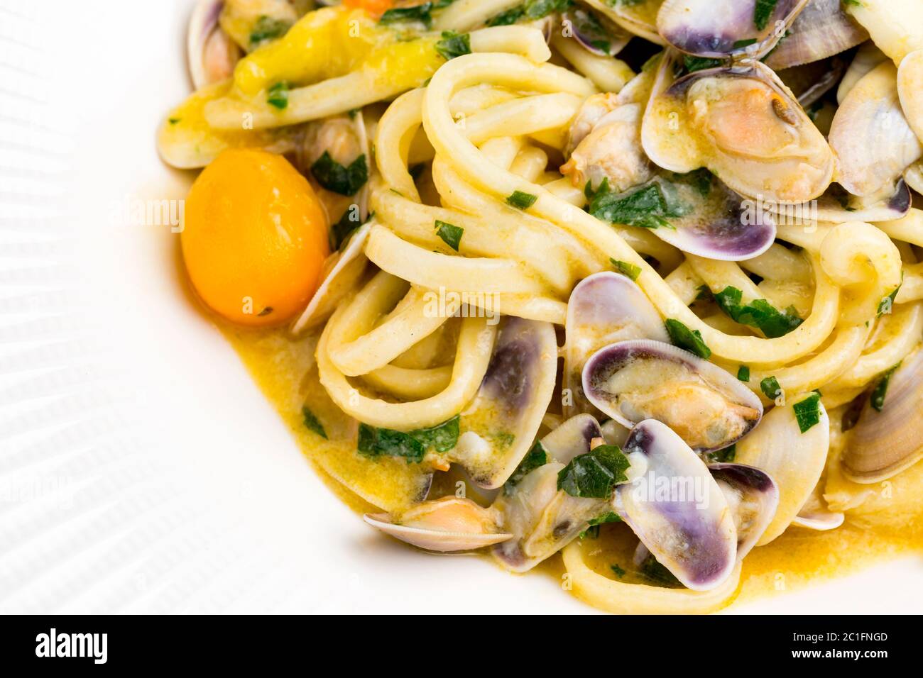 Linguine mit Meeresfrüchten, gelben Kirschtomaten und Petersilie Stockfoto