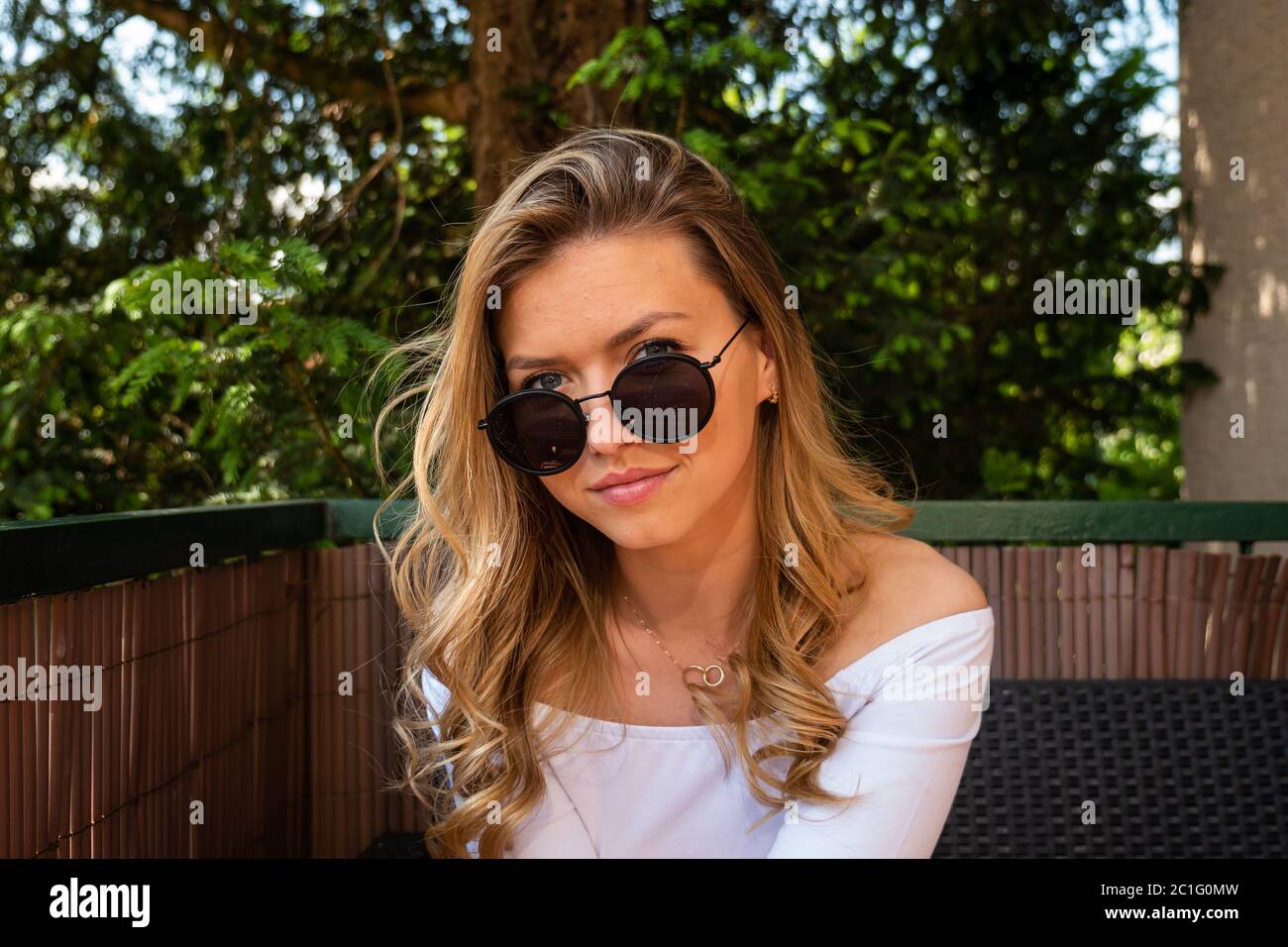 Portrait der schönen blonden Frau trägt Sonnenbrille Blick auf die Kamera. Mittlere Aufnahme. Stockfoto