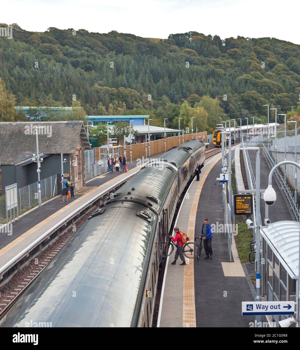 Fahrgäste mit Fahrrädern steigen am Bahnhof Stow in einen Scotrail-Zug auf der Grenzbahn ein Stockfoto