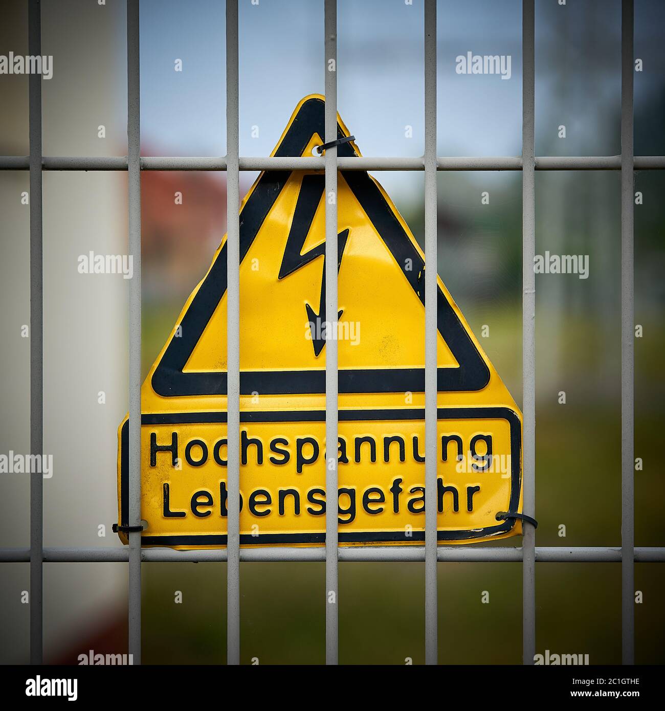 Schild mit der Aufschrift „Hochspannungs-Lebensgefahr“ auf einem Zaun Stockfoto