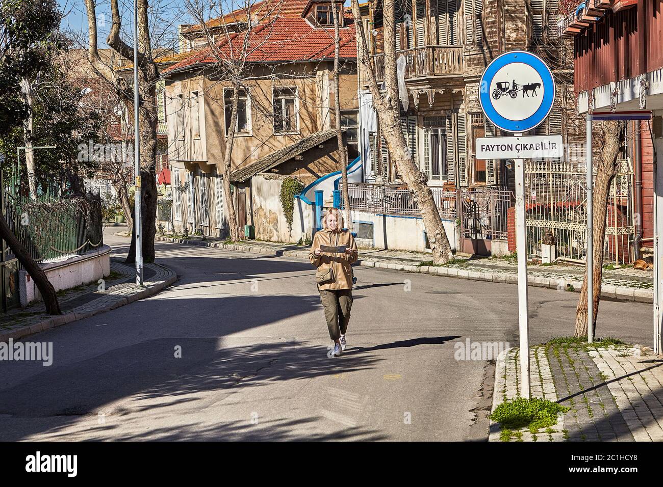 Eine junge kaukasische Frau, die während einer Touristenreise durch die Straßen der Insel Buyukada, Istanbuls Adalar-Viertel in der Türkei, schlendert. Weiße weibliche wa Stockfoto