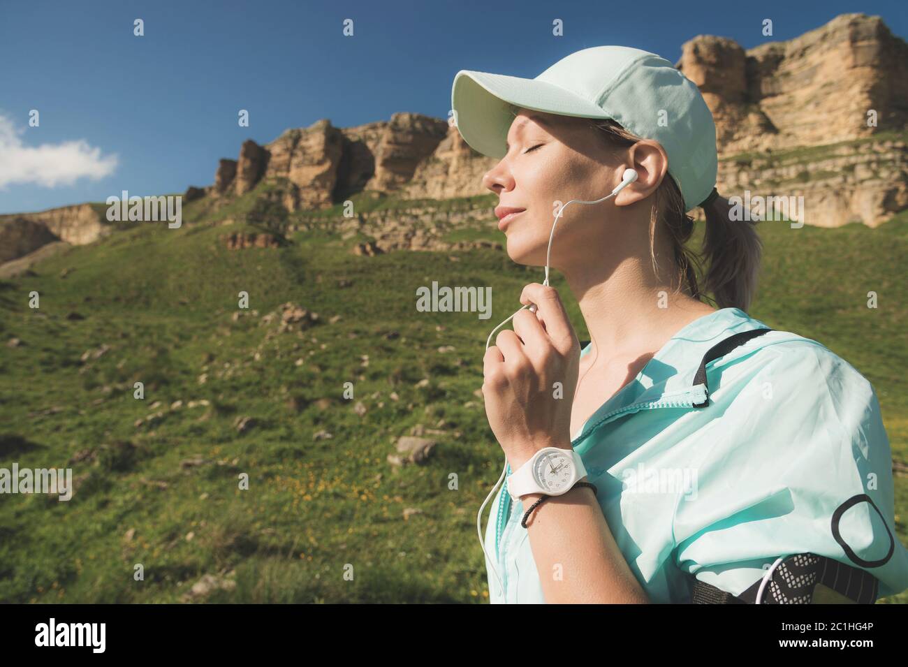 Fitness-Läufer Frau schließt die Augen und hört Musik über die Natur. Portrait von schönen Mädchen tragen Kopfhörer Ohrhörer und Stockfoto