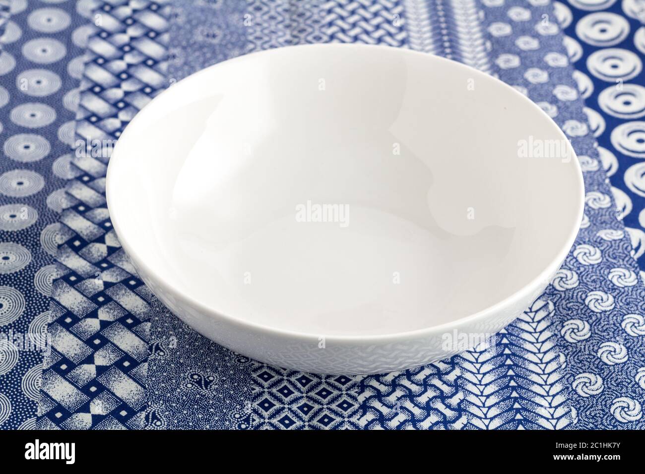 Schüssel leeren weißen Teller auf Blau und Weiß indigo Tischdecke Hintergrund Nahaufnahme Stockfoto