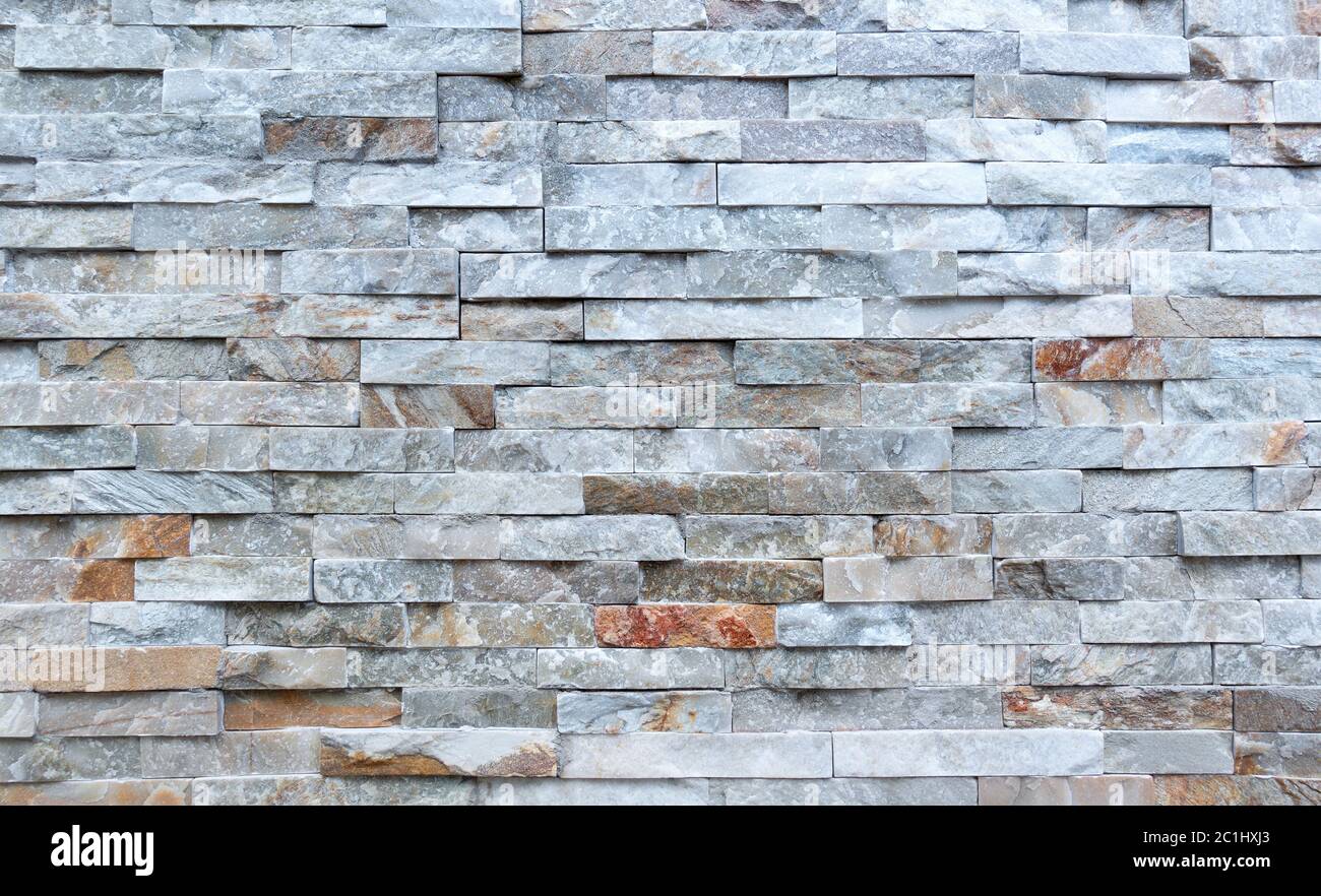Detail einer Steinwand aus rauhen, langgestreckten Steinen Stockfoto