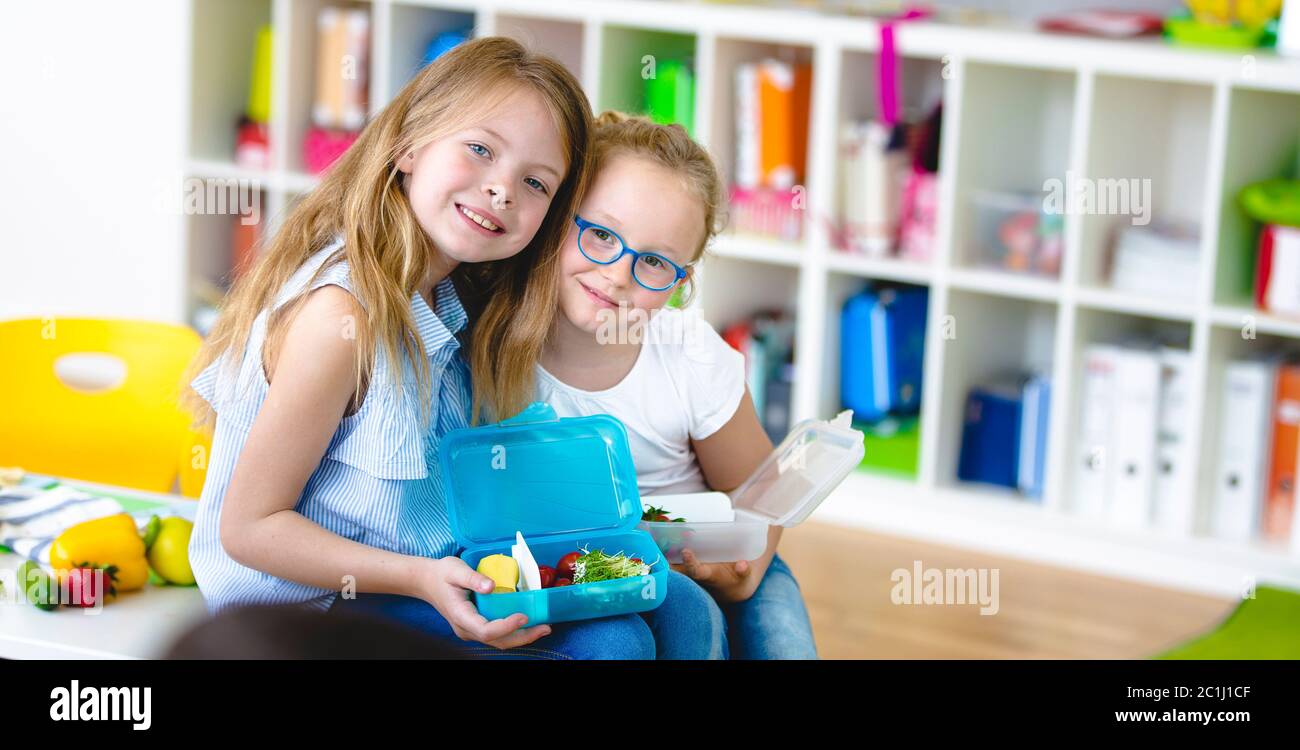 Zwei Schülerinnen genießen ihren gesunden Snack in der Schule Stockfoto