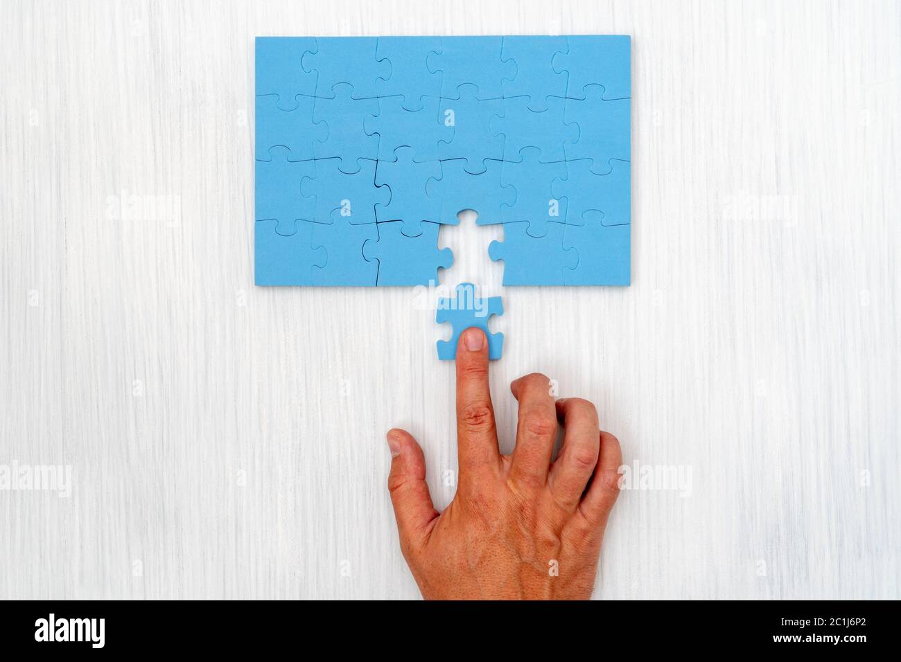 Hand legte das letzte Stück Puzzle Stockfoto