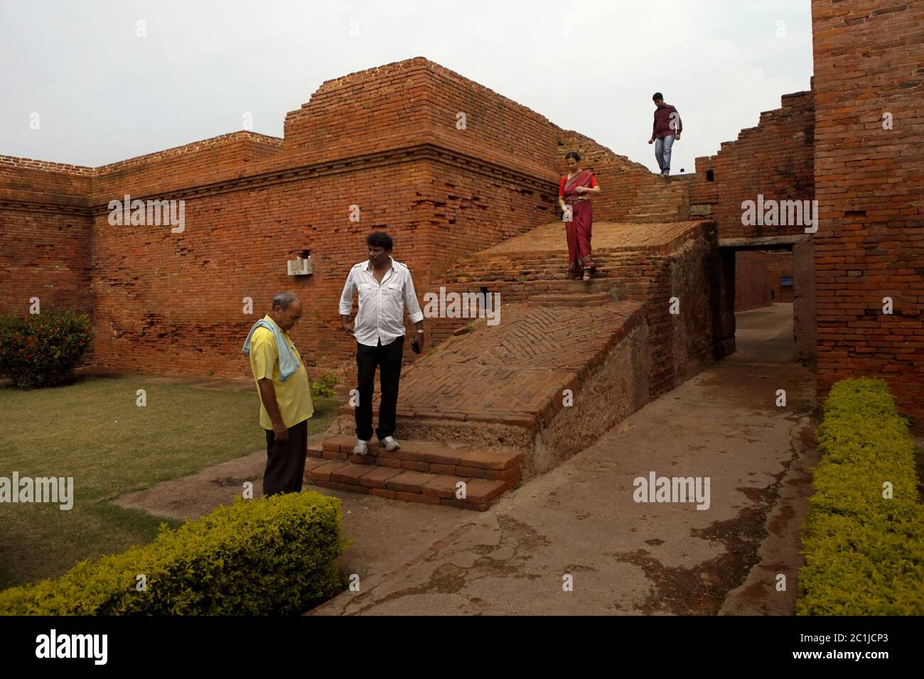 Ein Führer und eine lokale Familie in einem der ausgegrabenen Klöster im alten Nalanda buddhistischen Universitätskomplex in Nalanda, Bihar, Indien. Stockfoto