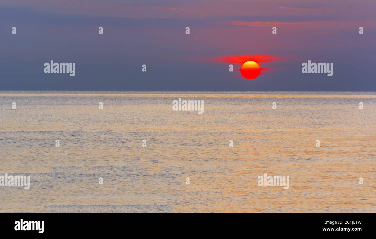 Wunderbarer Sonnenaufgang über einem ruhigen Meer Stockfoto