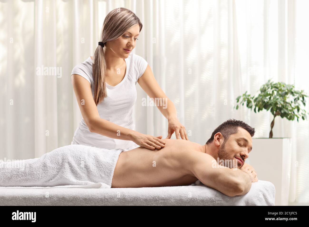 Weibliche Therapeutin, die einem Mann eine Rückenmassage in einem Massagezentrum gibt Stockfoto