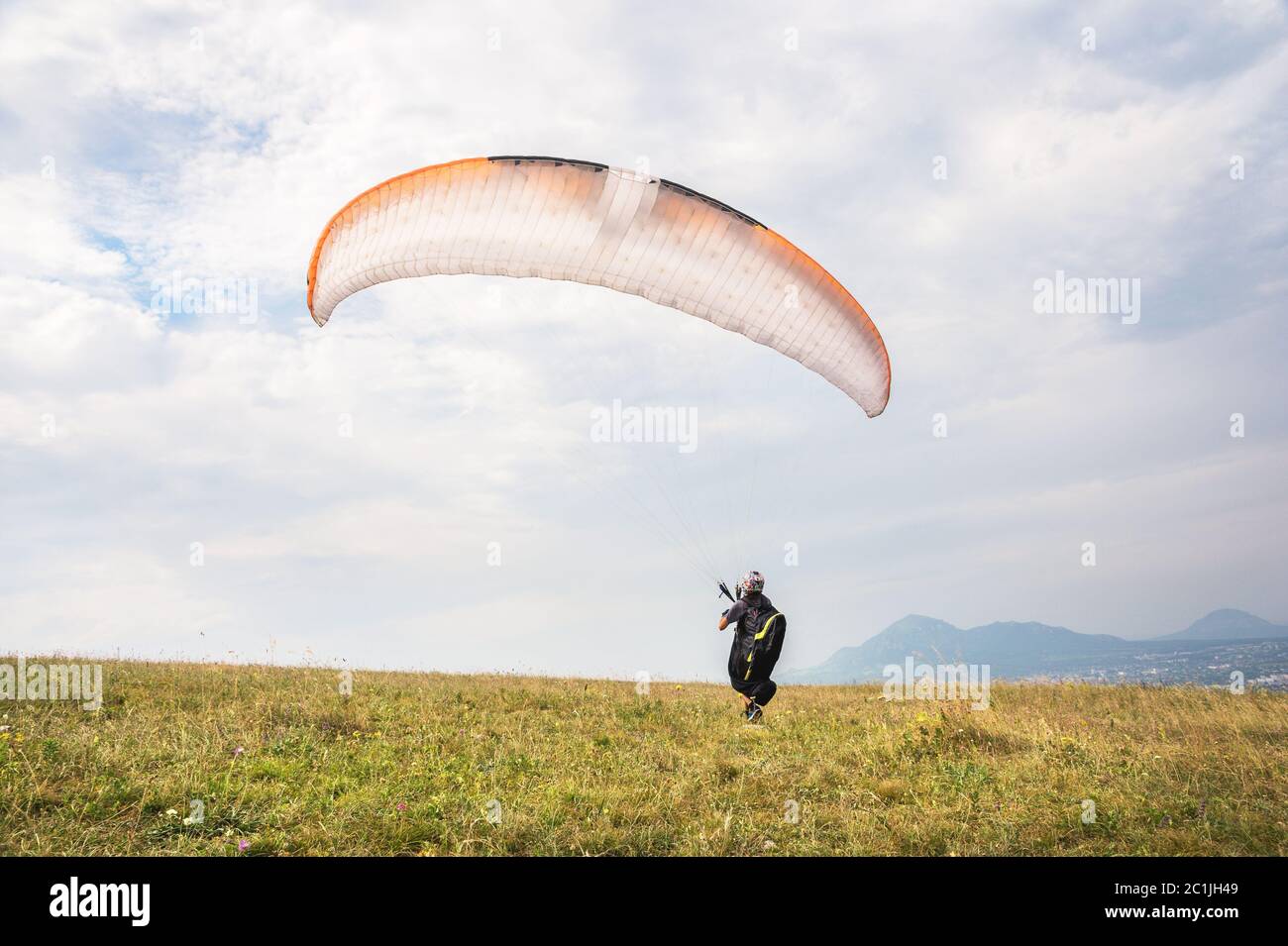 Der Gleitschirm öffnet seinen Fallschirm, bevor er vom Berg im Nordkaukasus abheben kann. Den Fallschirmflügel mit ai füllen Stockfoto