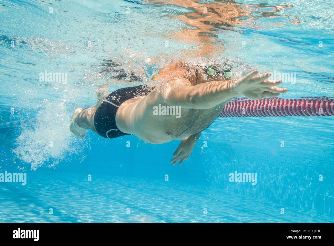 Männliche Schwimmer im Pool. Unterwasser Foto mit kopieren. Stockfoto