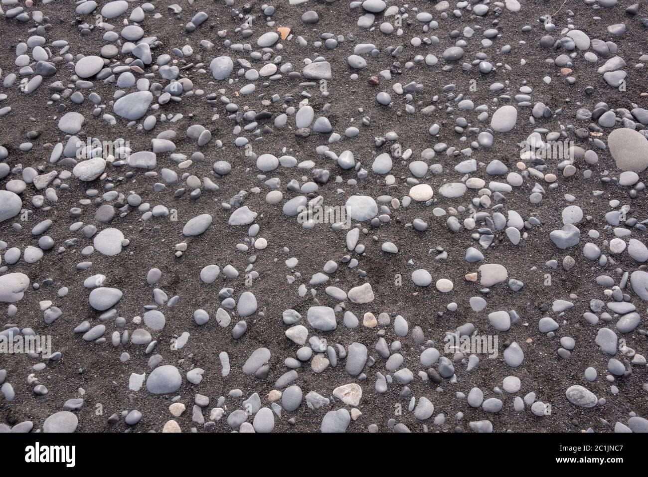 Schwarzer Vulkansand und weiße Kieselsteine am Strand von Vik, Südisland Stockfoto