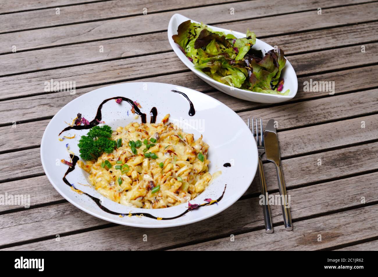 Käse spätzle auf einem Teller mit einem Salat. Stockfoto