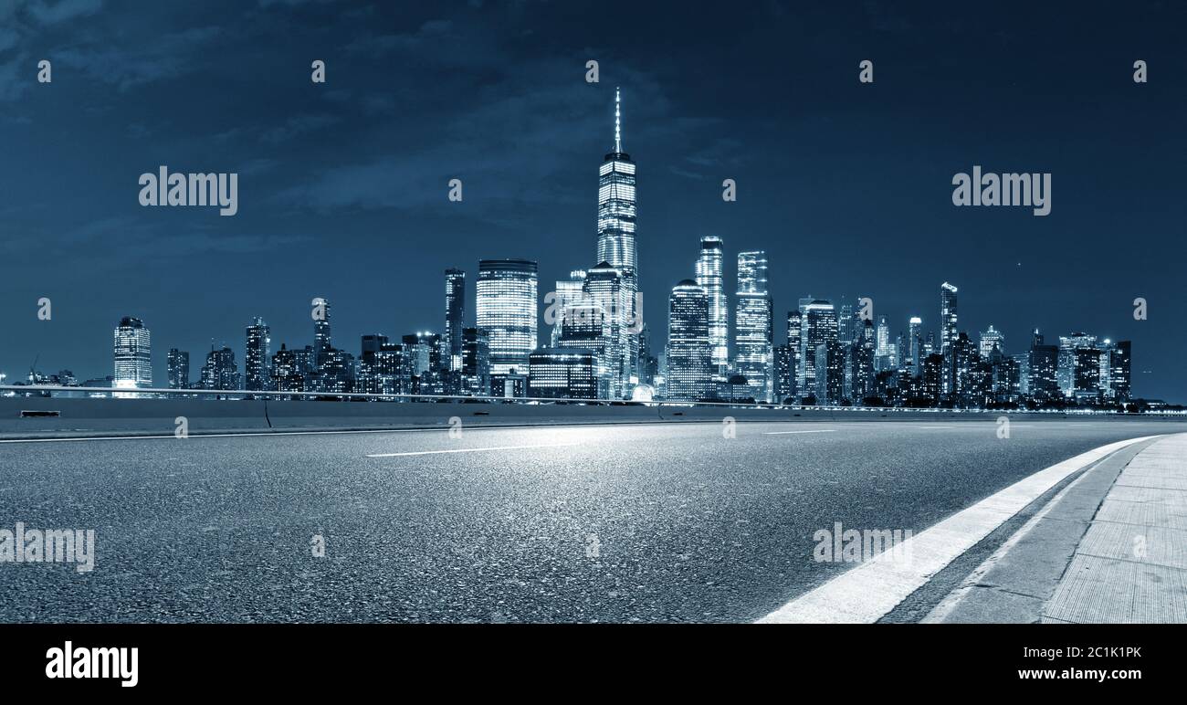 Leere Asphaltstraße mit Skyline der Stadt Stockfoto