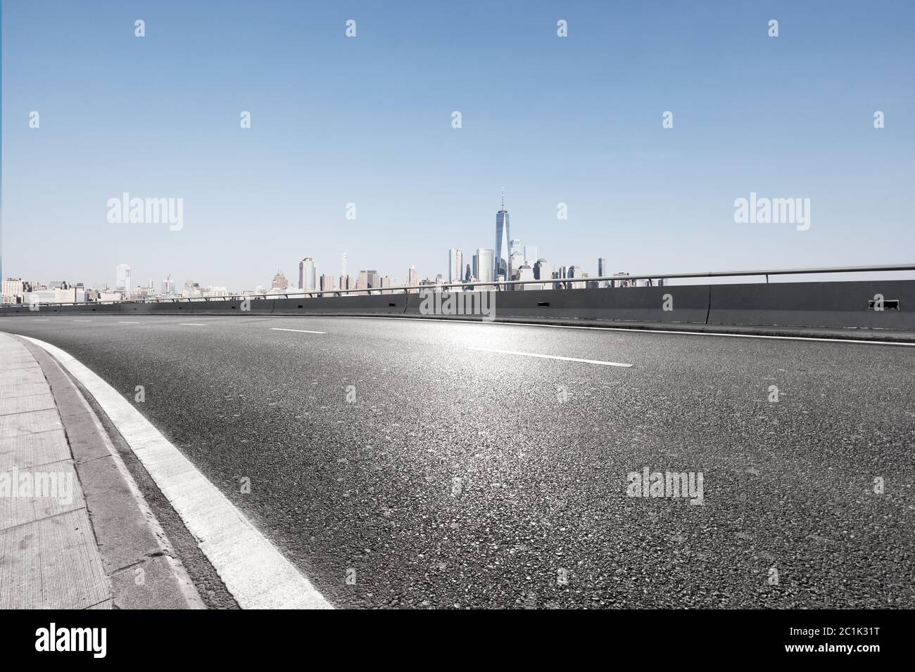 Leere Asphaltstraße mit Skyline der Stadt Stockfoto