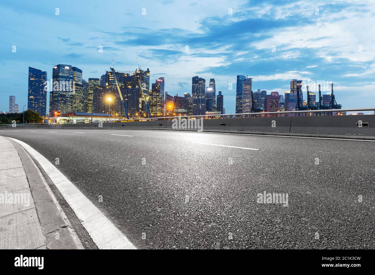 Leere Asphaltstraße mit Skyline der Stadt Stockfoto