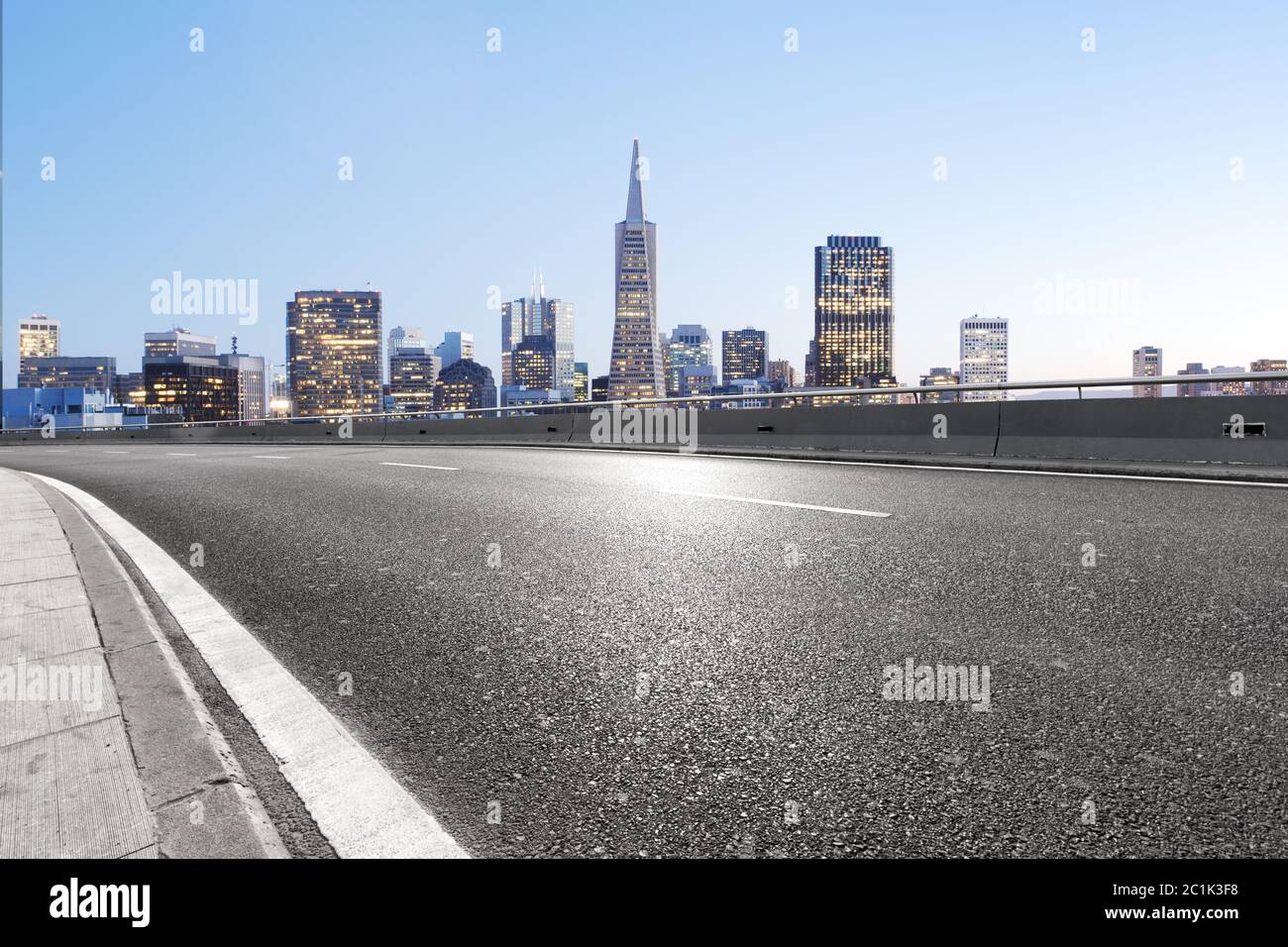 Leere Asphaltstraße mit Skyline der Stadt Stockfoto