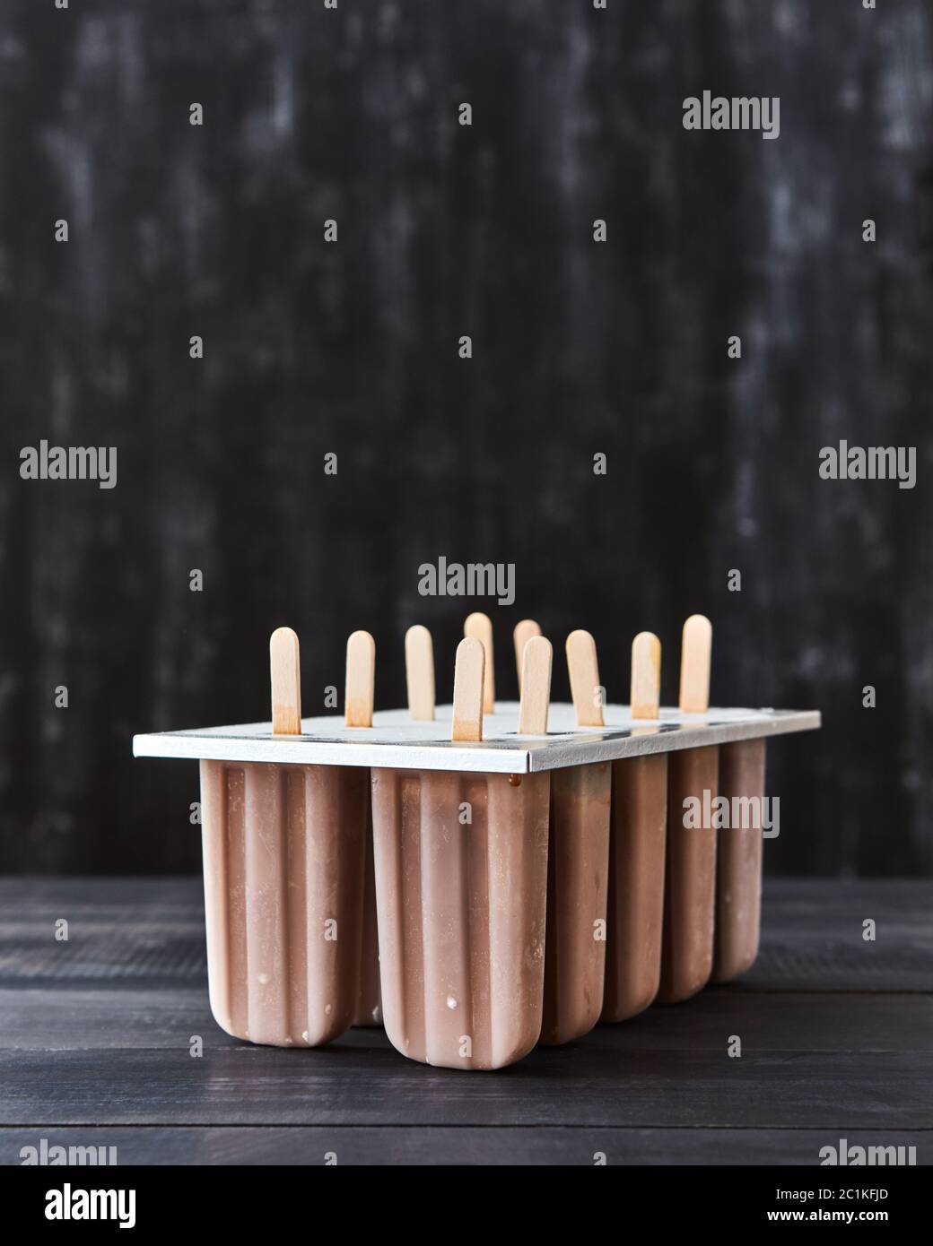 Kaffee Eis am Stiel in Kunststoff Form auf einem schwarzen Holz- Hintergrund mit kopieren. Stockfoto