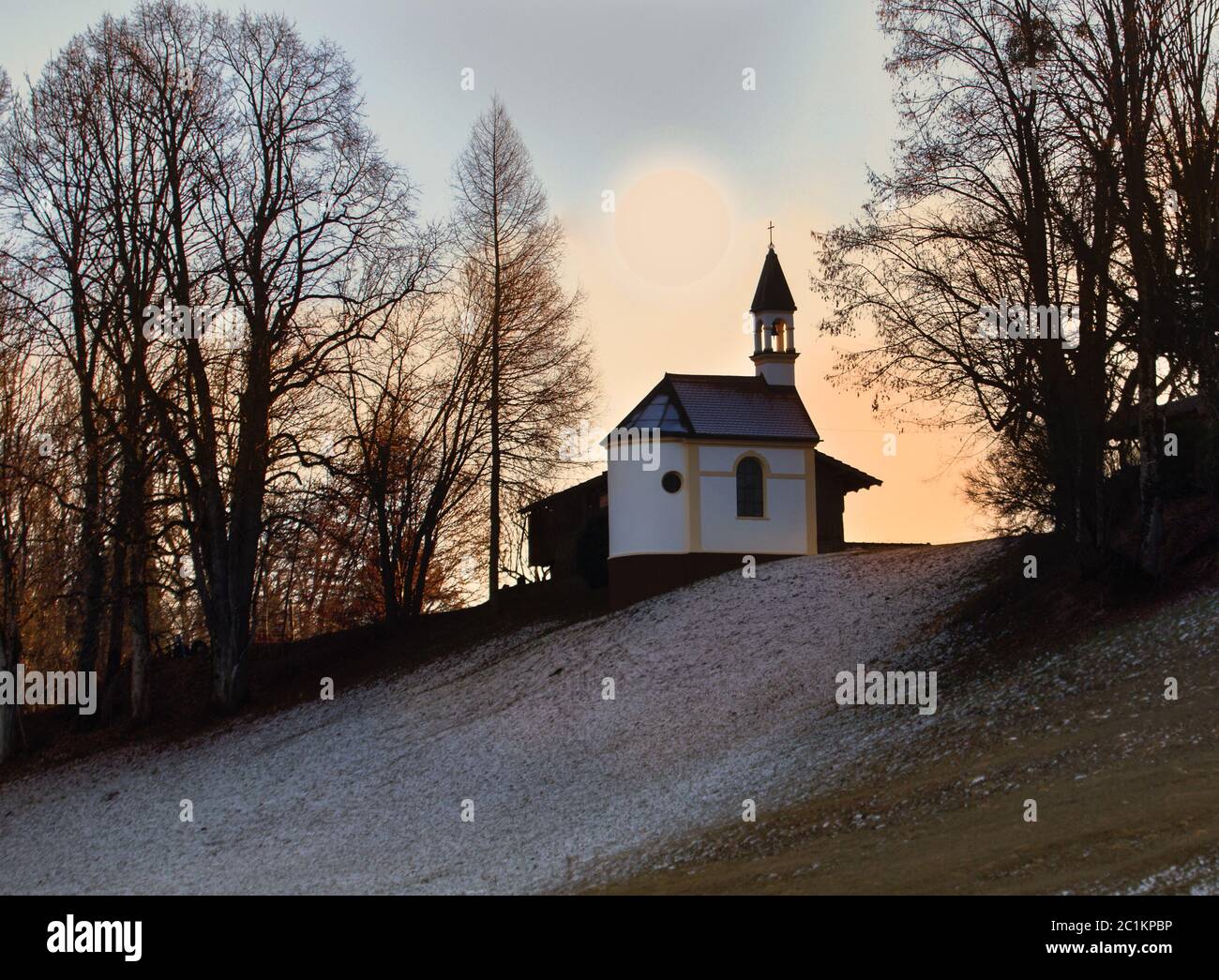 Hauskapelle an einem Hang nahe einem Bauernhof. Stockfoto