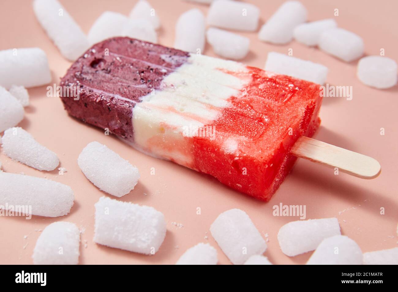 Obstbeere appetitlich Eis Lolly mit Eisscheiben auf einem rosa Hintergrund. Stockfoto