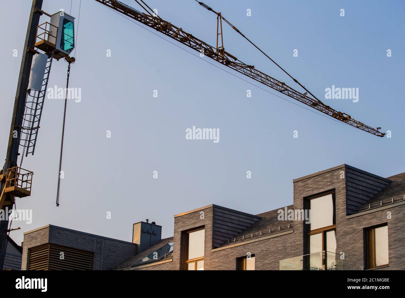 Industriebau Nahaufnahme eines Krans gegen blauen Himmel im Hintergrund - Baustelle Fortschritt Architektur Entwicklung Stockfoto