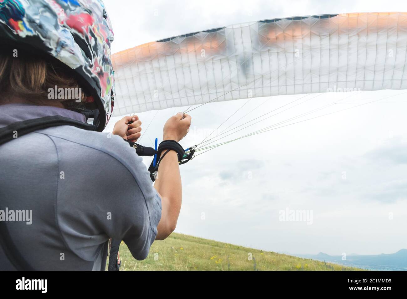 Nahaufnahme der Gleitschirm öffnet seinen Fallschirm vor dem Start. Vor dem Start den Fallschirmflügel mit Luft befüllen Stockfoto