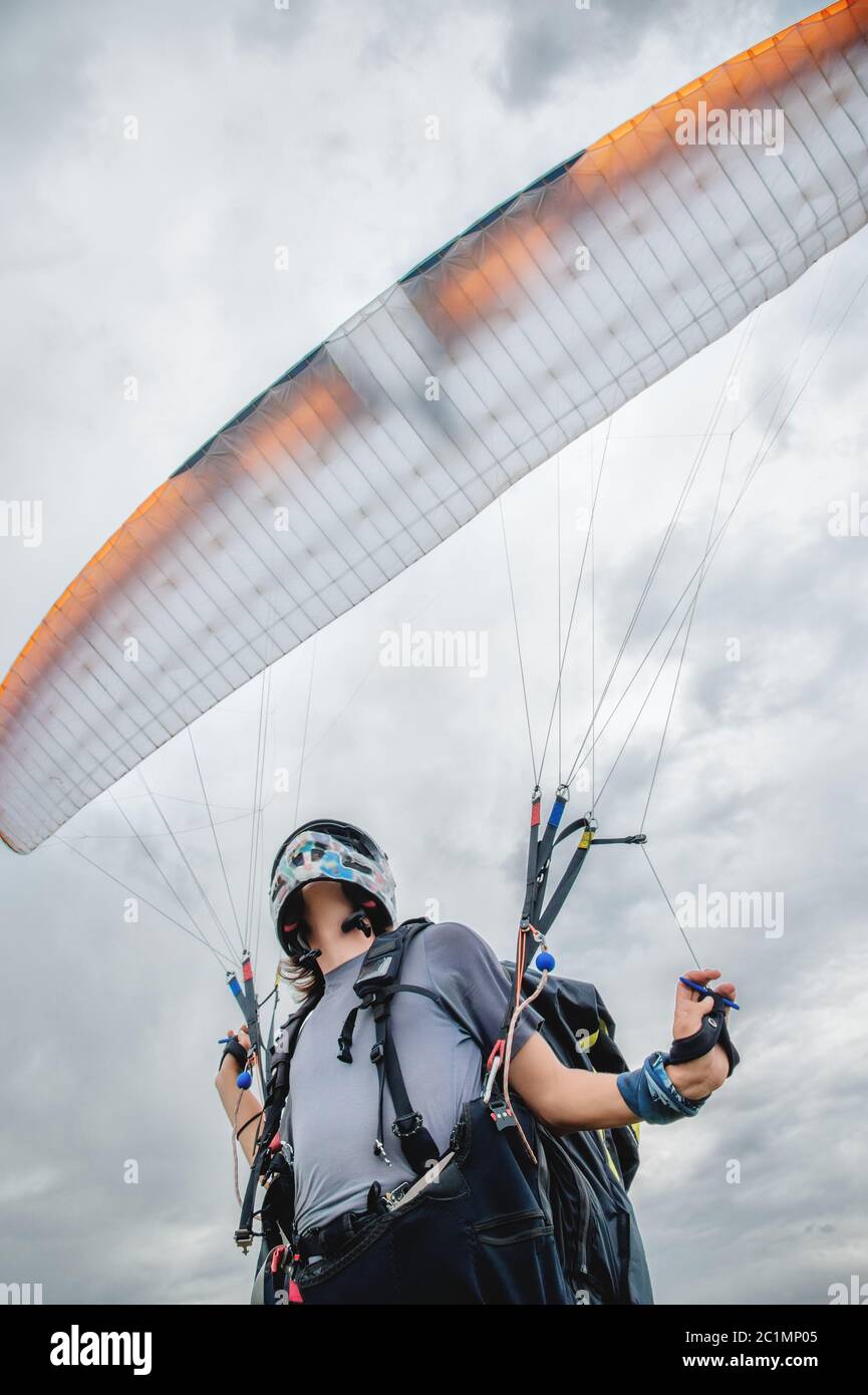 Nahaufnahme der Gleitschirm öffnet seinen Fallschirm vor dem Start. Vor dem Start den Fallschirmflügel mit Luft befüllen Stockfoto