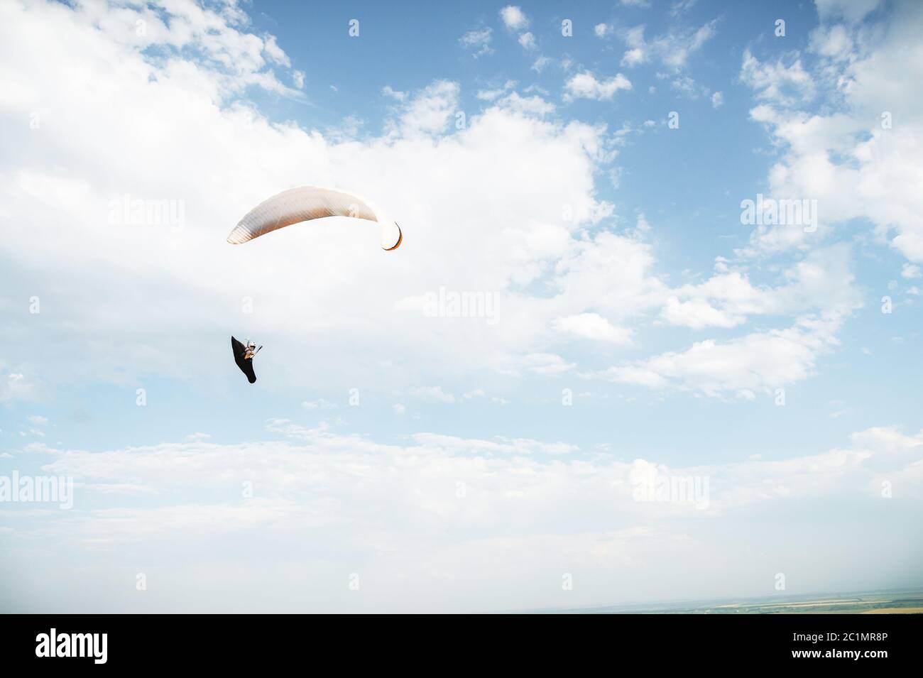 Allein Gleitschirm fliegen in den blauen Himmel vor dem Hintergrund der Wolken. Paragliding am Himmel an einem sonnigen Tag Stockfoto Allein Gleitschirm fliegen in den blauen Himmel vor dem Hintergrund der Wolken. Paragliding am Himmel an einem sonnigen Tag Stockfoto