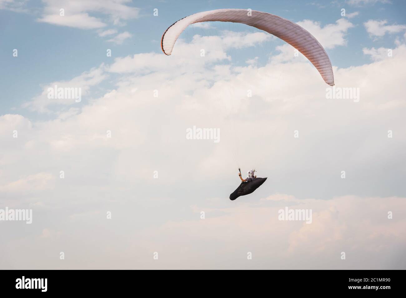 Allein Gleitschirm fliegen in den blauen Himmel vor dem Hintergrund der Wolken. Paragliding am Himmel an einem sonnigen Tag Stockfoto Allein Gleitschirm fliegen in den blauen Himmel vor dem Hintergrund der Wolken. Paragliding am Himmel an einem sonnigen Tag Stockfoto