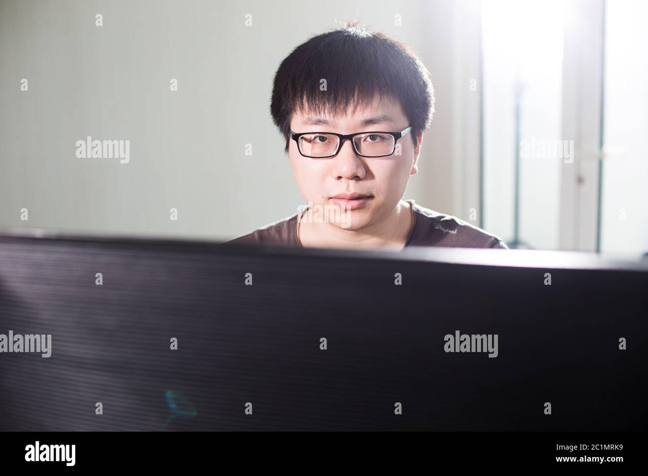 Junger Mann, der mit Computer arbeitet Stockfoto