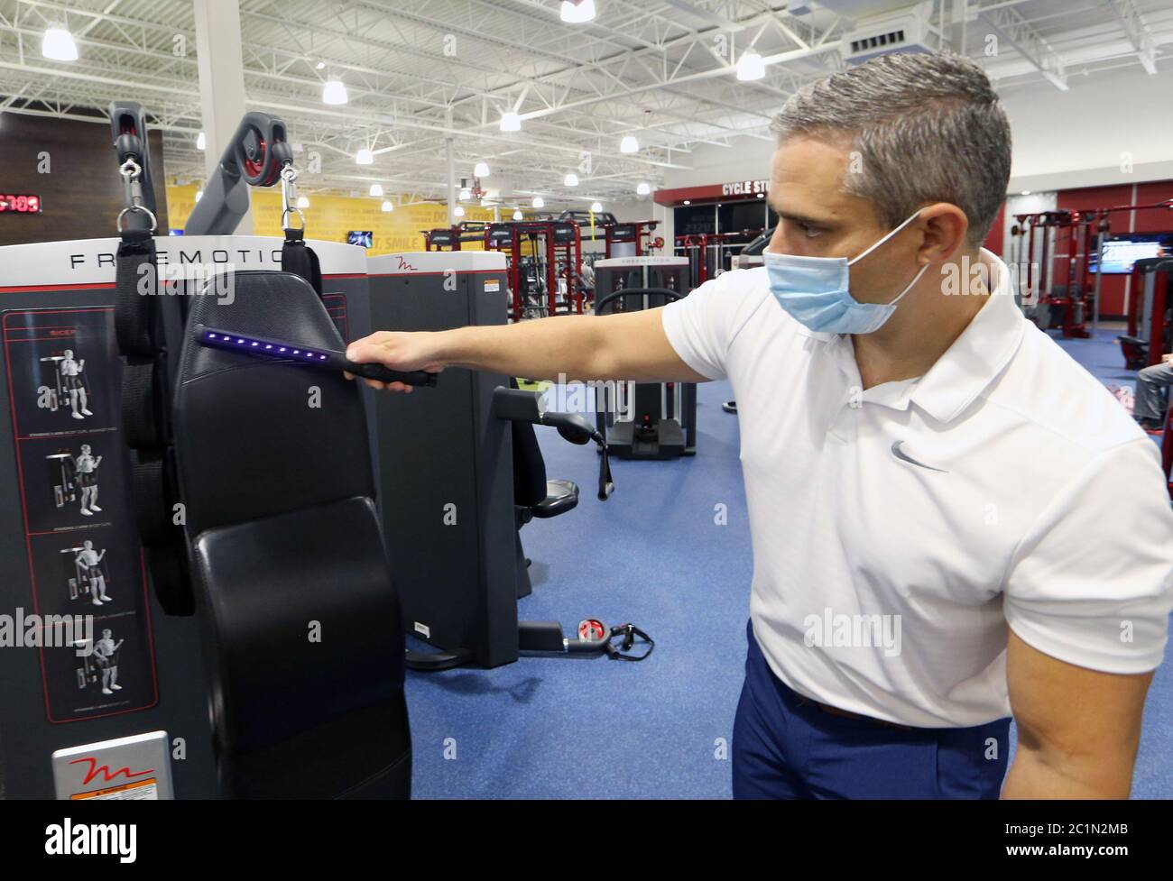 Maplewood, Usa. Juni 2020. Matt Bohn, Mitarbeiter des Club Fitness Gym, nutzt ein ultraviolettes Licht, um am ersten Tag ihrer Wiedereröffnung in Maplewood, Missouri, am Montag, 15. Juni 2020, Bakterien auf einem Ausrüstungstück abzutöten. Alle Geschäfte im Bezirk St. Louis sind jetzt nach drei Monaten Schließung aufgrund der Coronavirus-Pandemie geöffnet. Die meisten Unternehmen arbeiten mit einer Kapazität von 25 Prozent, wobei diese Zahl in den folgenden Wochen steigen wird. Foto von Bill Greenblatt/UPI Kredit: UPI/Alamy Live News Stockfoto