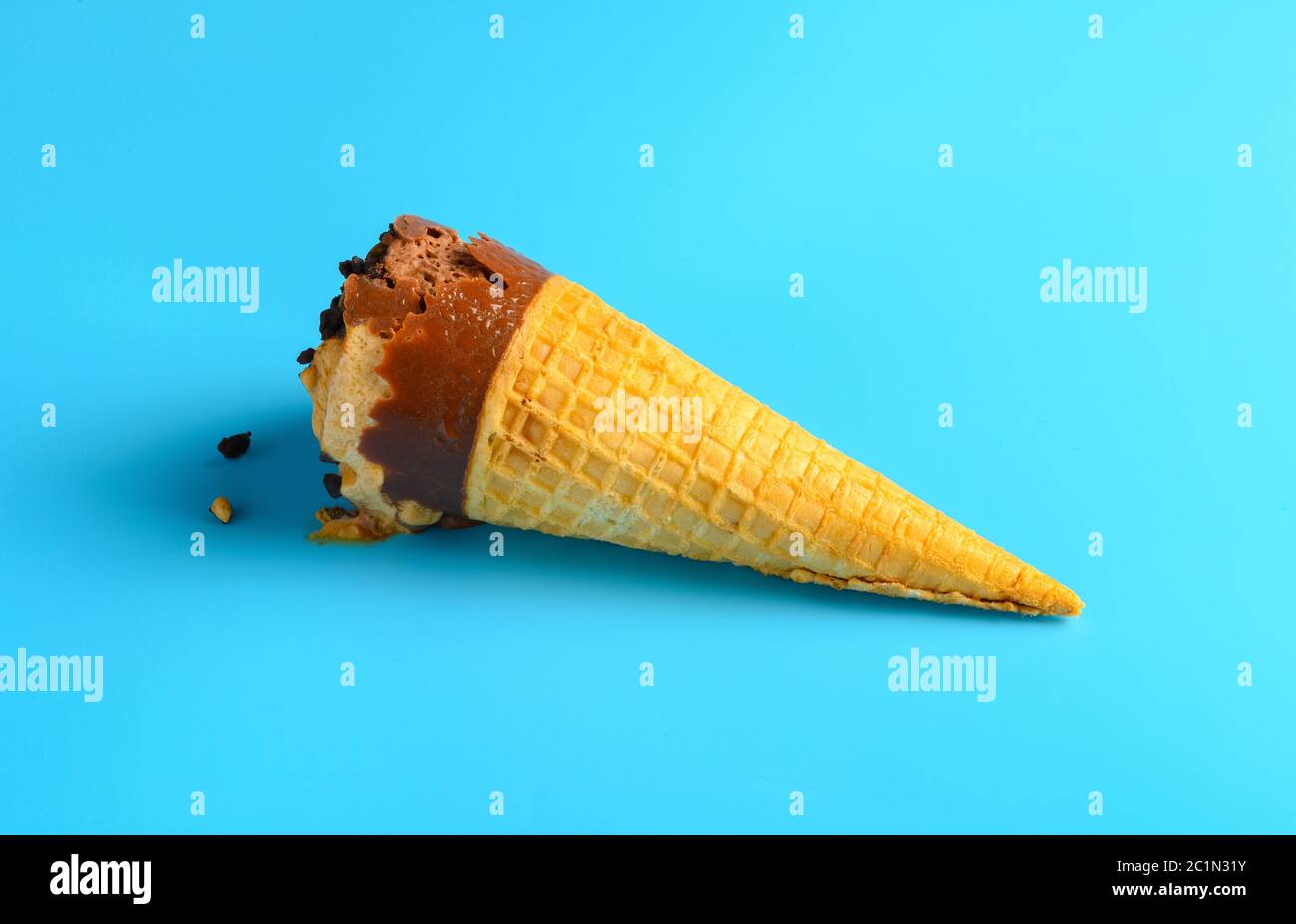 Schokolade und Kaffee Geschmack Eis Kegel beginnt schmelzen auf blauem Hintergrund Stockfoto