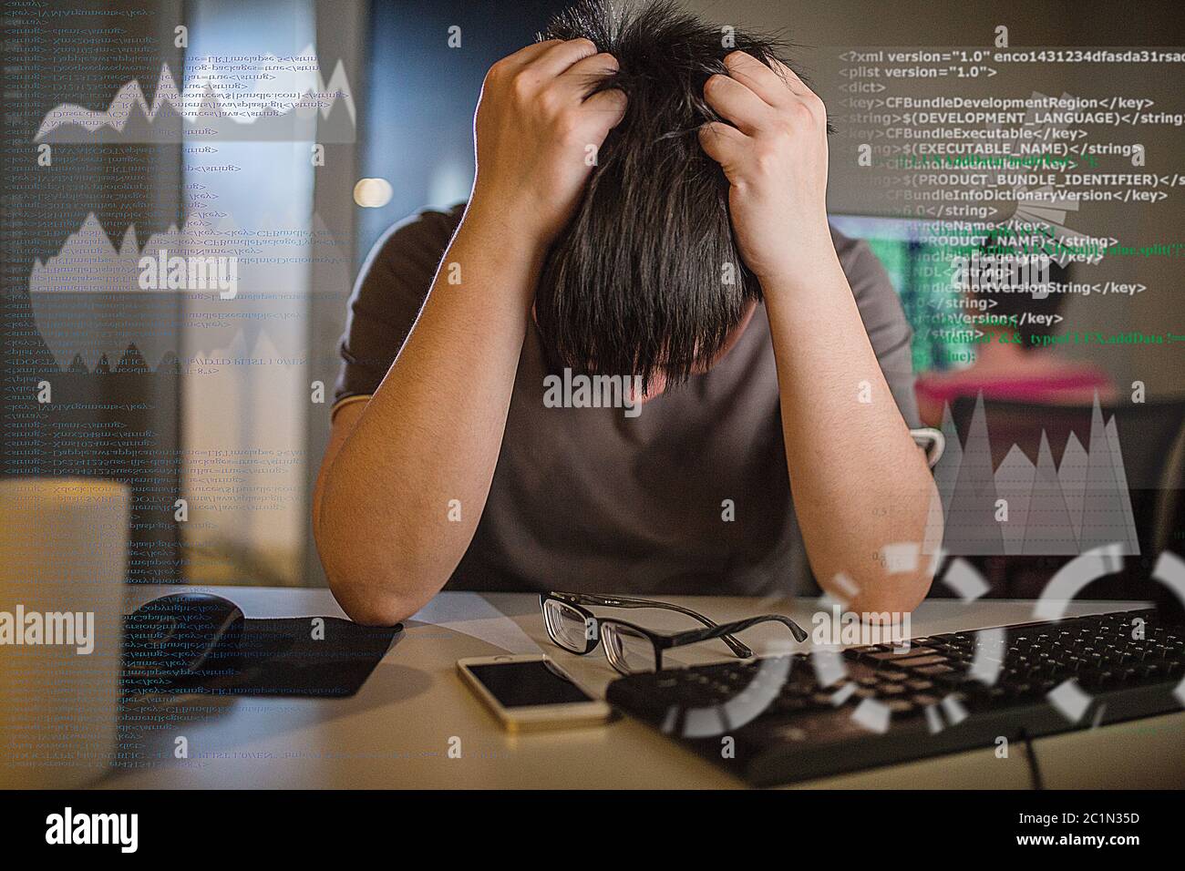 yang Mann arbeitet Überstunden mit Computer gebunden Stockfoto