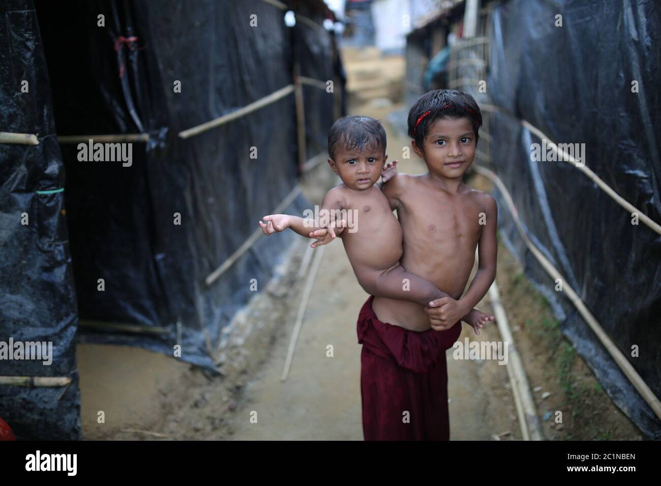 Rohingya-Kind posiert mit ihrer Schwester in einem provisorischen Lager im Palangkhali-Flüchtlingslager in Cox's Bazar, Bangladesch, Mittwoch, 4. Oktober 2017 Stockfoto