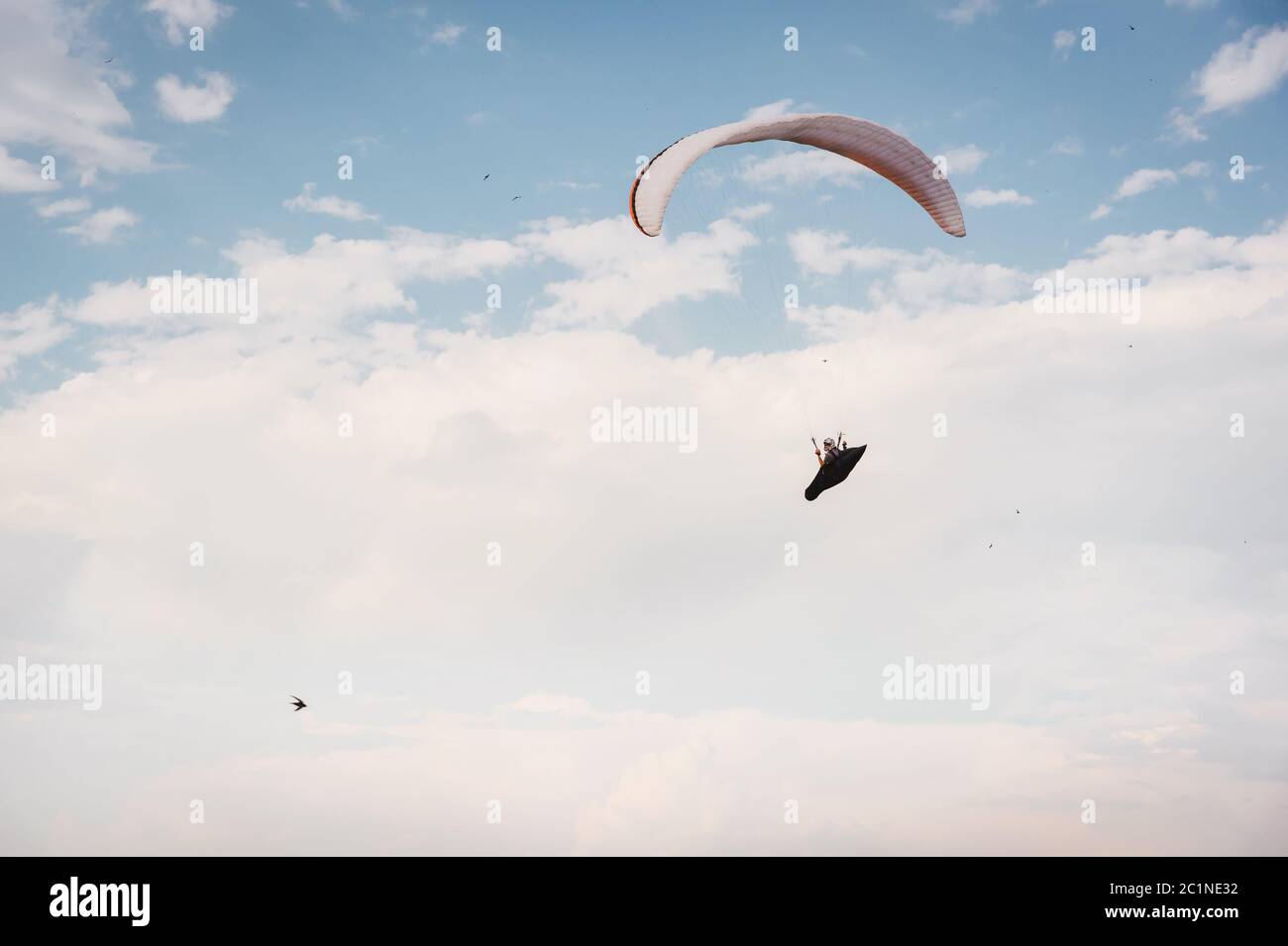 Allein Gleitschirm fliegen in den blauen Himmel vor dem Hintergrund der Wolken. Paragliding am Himmel an einem sonnigen Tag Stockfoto Allein Gleitschirm fliegen in den blauen Himmel vor dem Hintergrund der Wolken. Paragliding am Himmel an einem sonnigen Tag Stockfoto