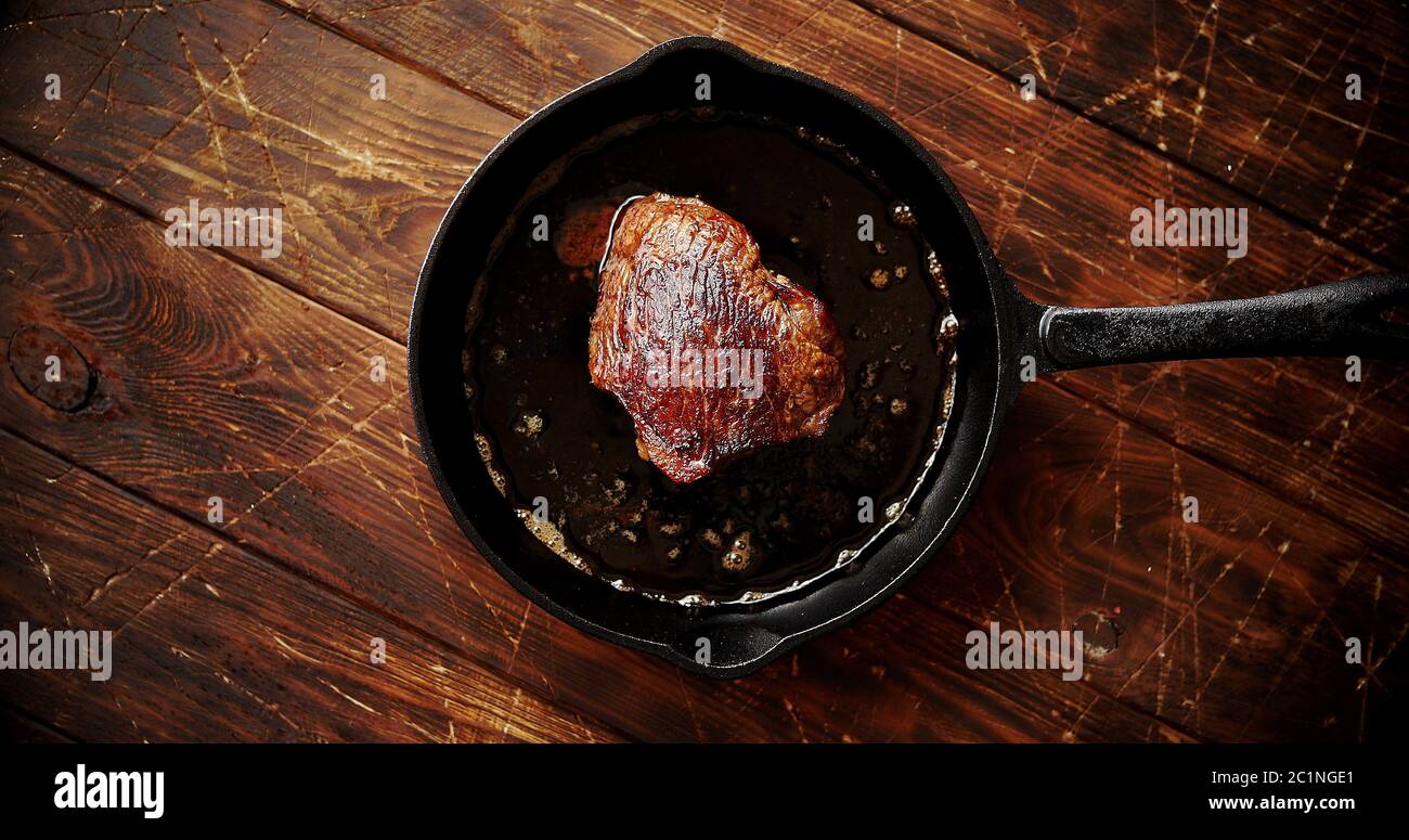 Stück Fleisch gebraten in Öl auf Pan Stockfoto