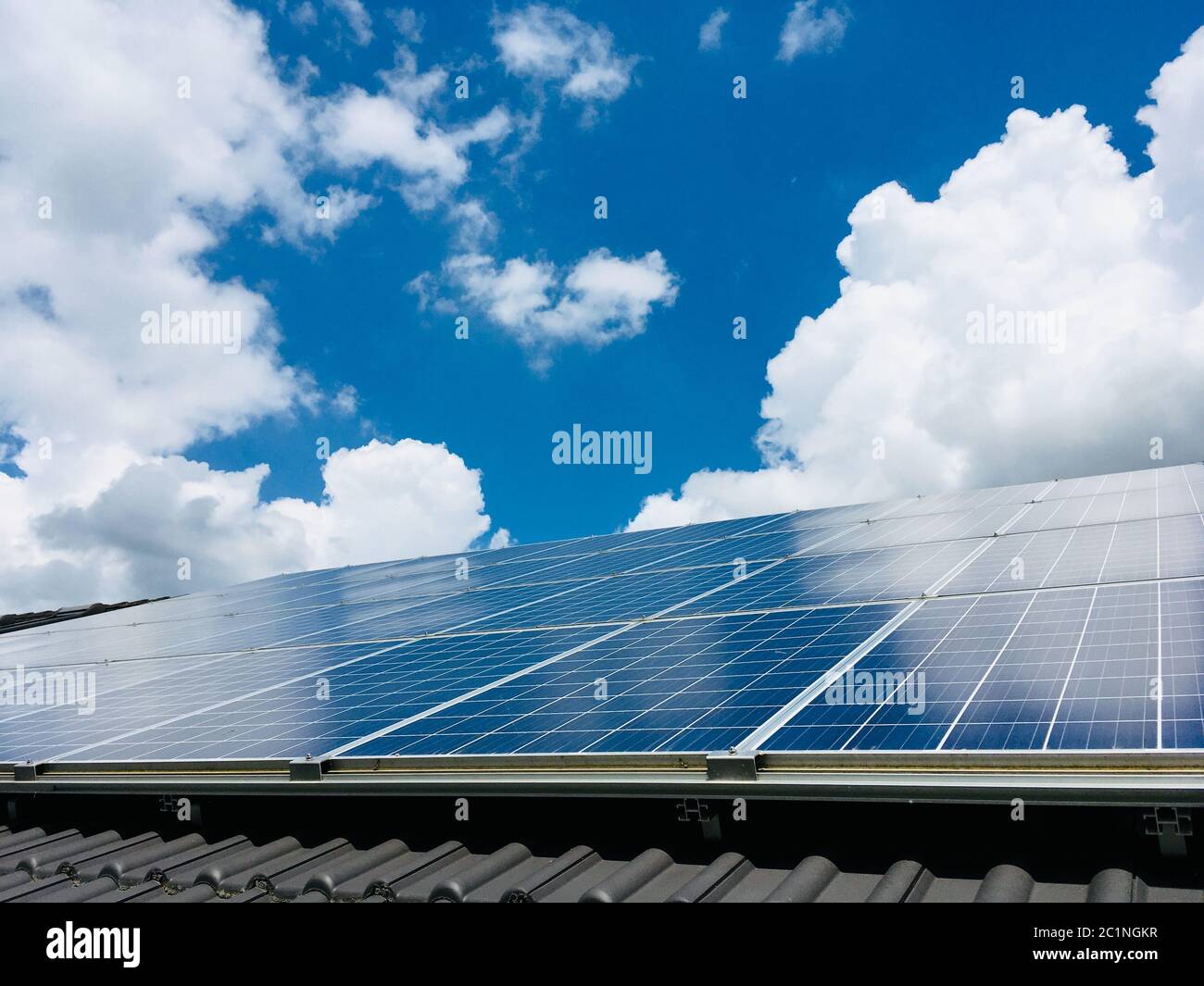 Solar Green Alternative Power, Photovoltaik-Panels auf dem Dach und blauer Himmel mit Wolken Stockfoto