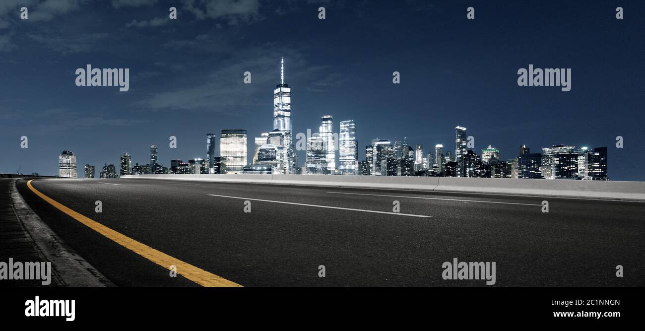 Leere Asphaltstraße mit modernem Stadtbild New york bei Nacht Stockfoto