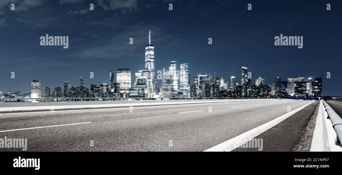 Leere Asphaltstraße mit modernem Stadtbild New york bei Nacht Stockfoto