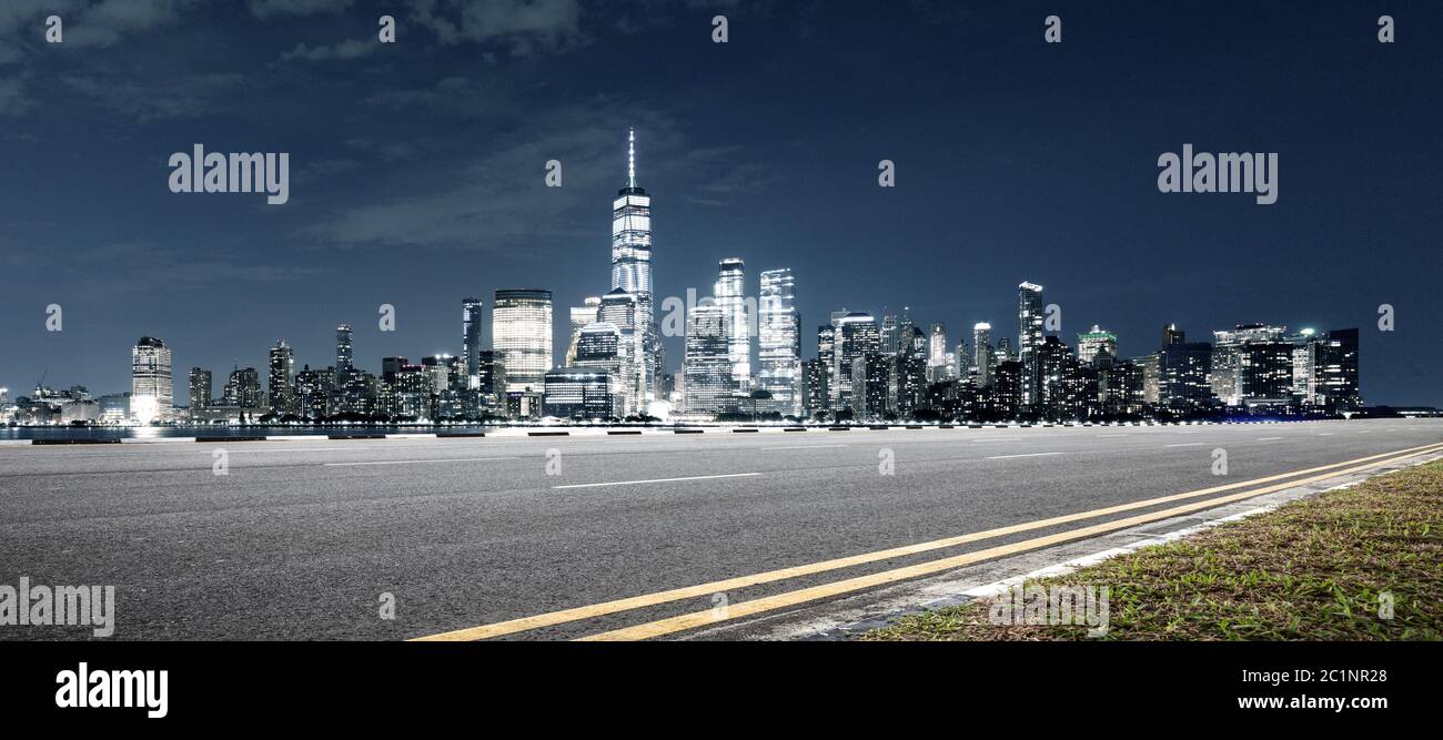 Leere Asphaltstraße mit modernem Stadtbild New york bei Nacht Stockfoto