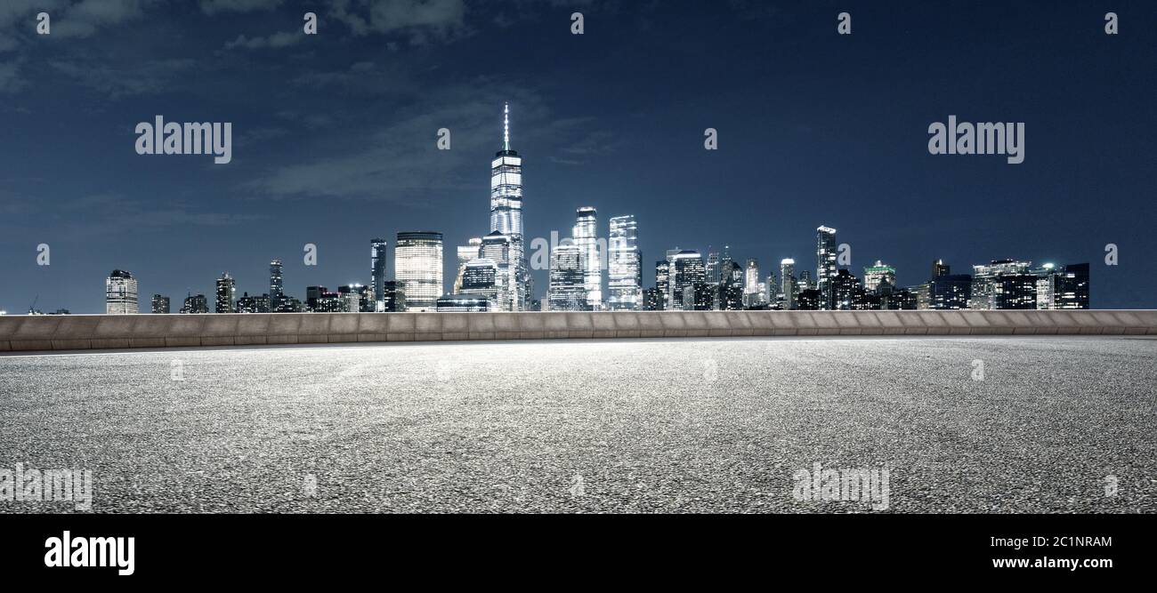 Leere Asphaltstraße mit modernem Stadtbild New york bei Nacht Stockfoto