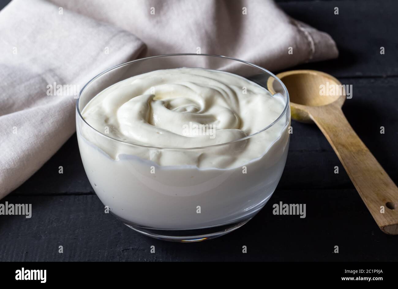 Joghurt im Glas Schale mit Löffel aus Holz - selektive Fokus natürliche griechischer Joghurt Hintergrund Stockfoto