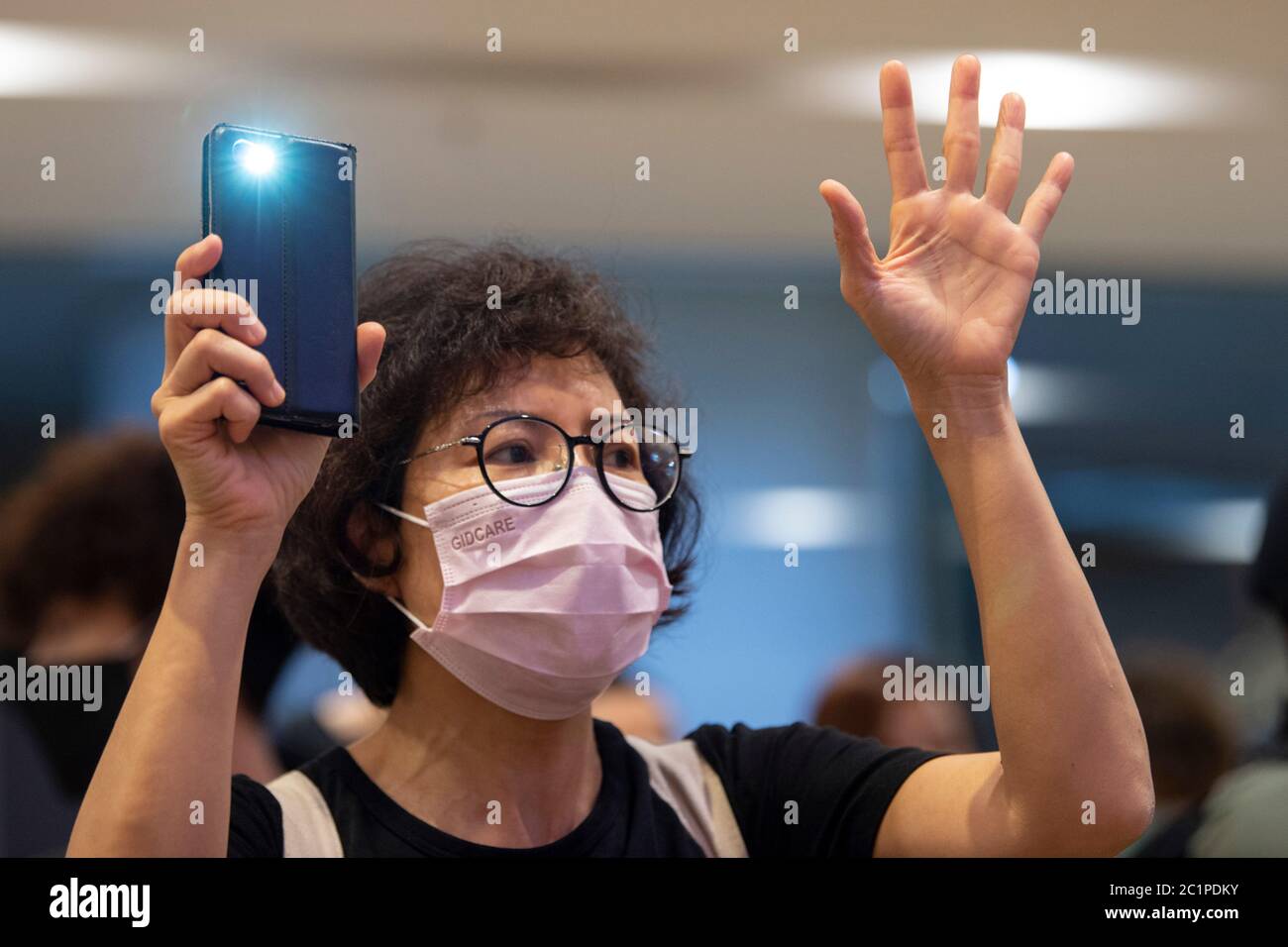 HONGKONG, HONGKONG SAR, CHINA: 15. JUNI 2020. Demonstranten halten die "5 Forderungen nicht weniger" Hand-Zeichen in Pacific Place Mall in Admiralty Hongkong. Sie sind dort, um des ersten Todes von Demokratiedemonstranten vor einem Jahr zu gedenken. Marco Leung starb am 15. Juni 2019 an Gerüsten vor dem Gebäude. Er wurde bekannt als der Regenmantel Mann. Alamy Stock Image/Jayne Russell Stockfoto