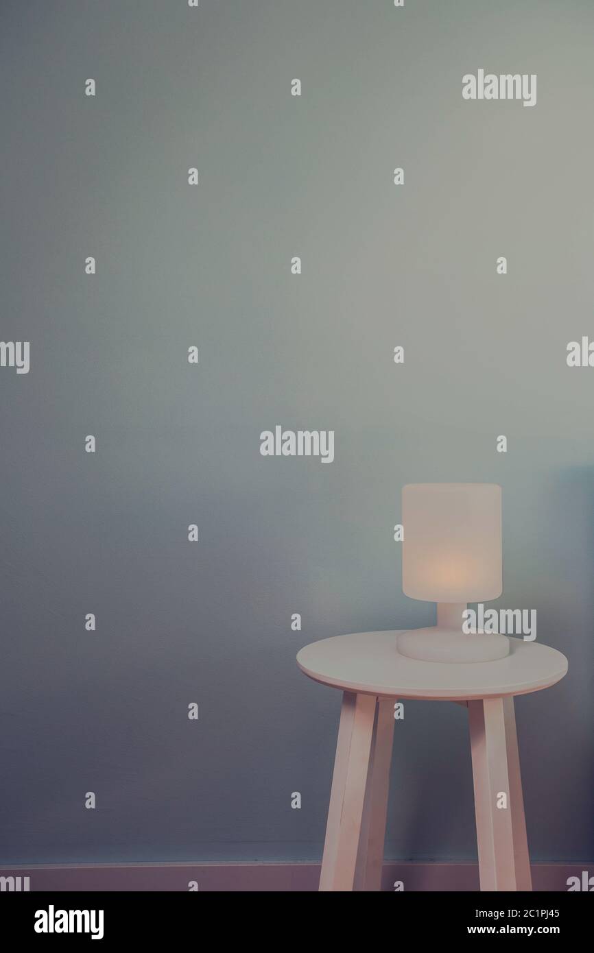 Lampe Nachtlicht auf Holz Tisch mit blauen Wand für Text. Vintage Effekt stil Bild. Minimalen Begriff. Hintergrund Textur Stockfoto