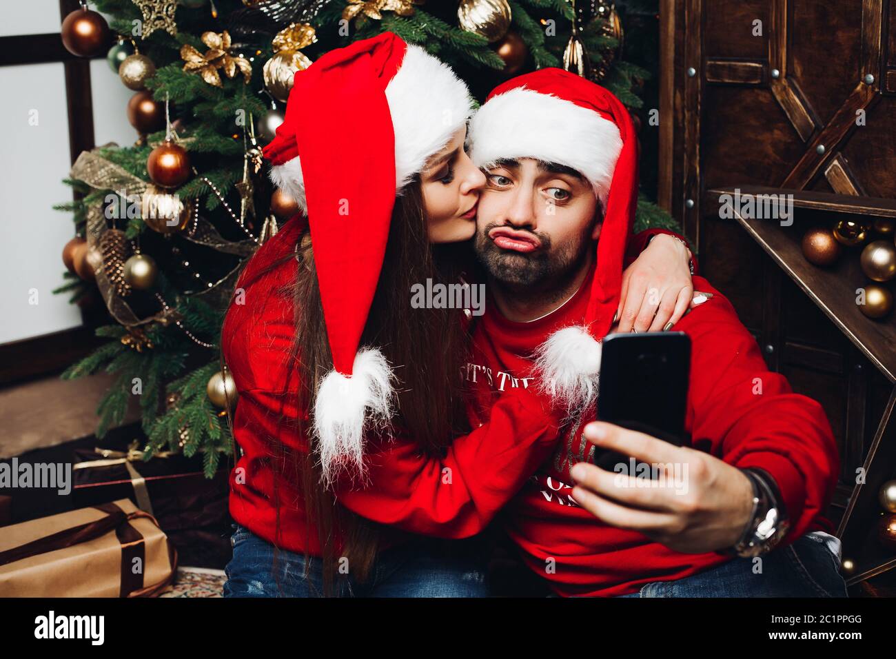Paar schöne in santa Hüte, selfie auf Handy. Stockfoto