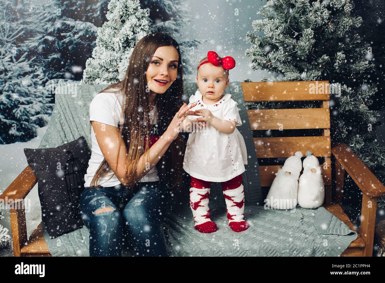 Liebevolle Mutter schmücken Weihnachtsbaum mit Baby. Stockfoto